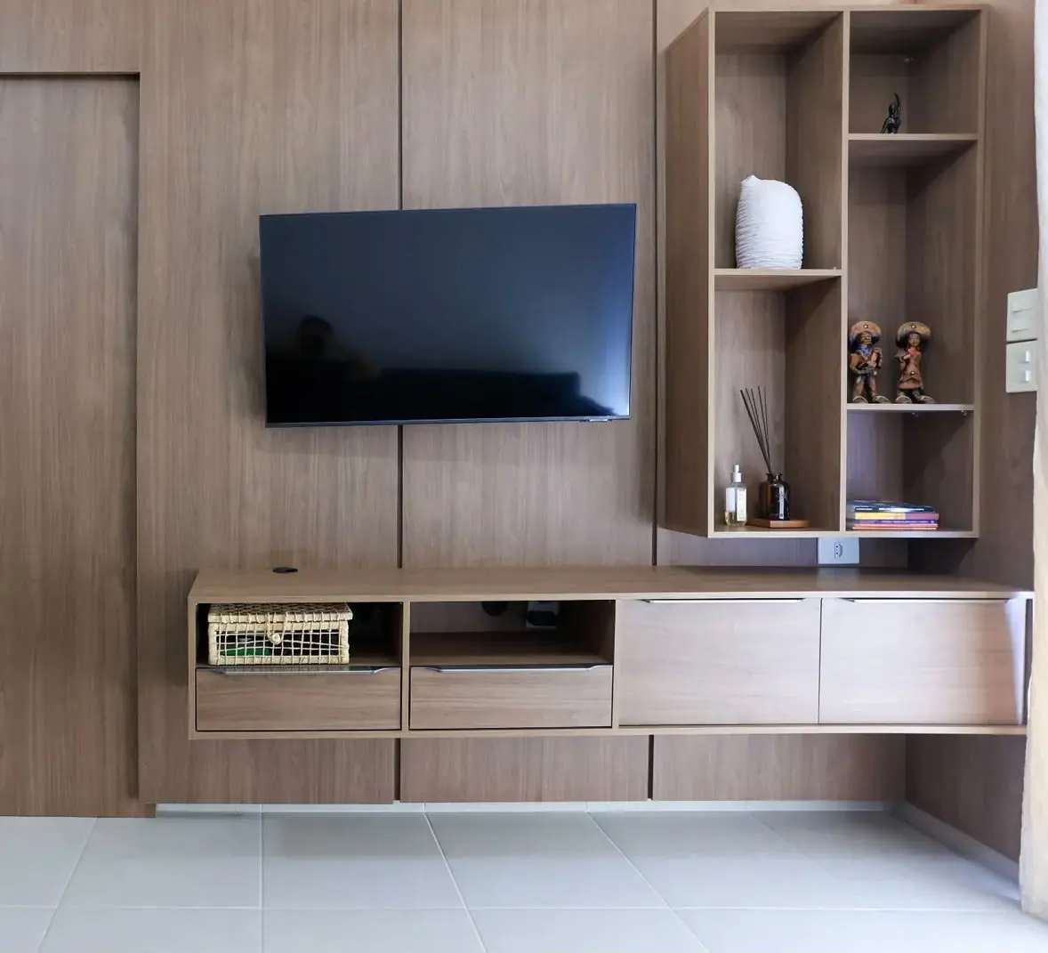 Painel com torre de nichos — Painel amadeirado com torre de nichos verticais assimétricos e rack suspenso com gavetas de perfil.